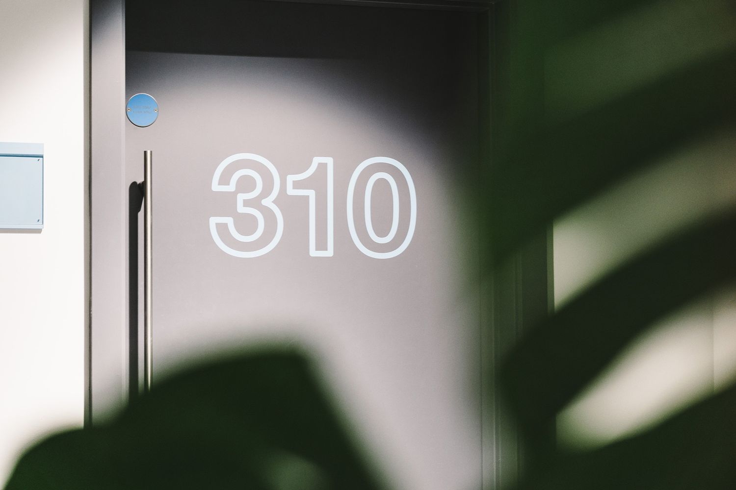 Cut vinyl door numbers on a black office door