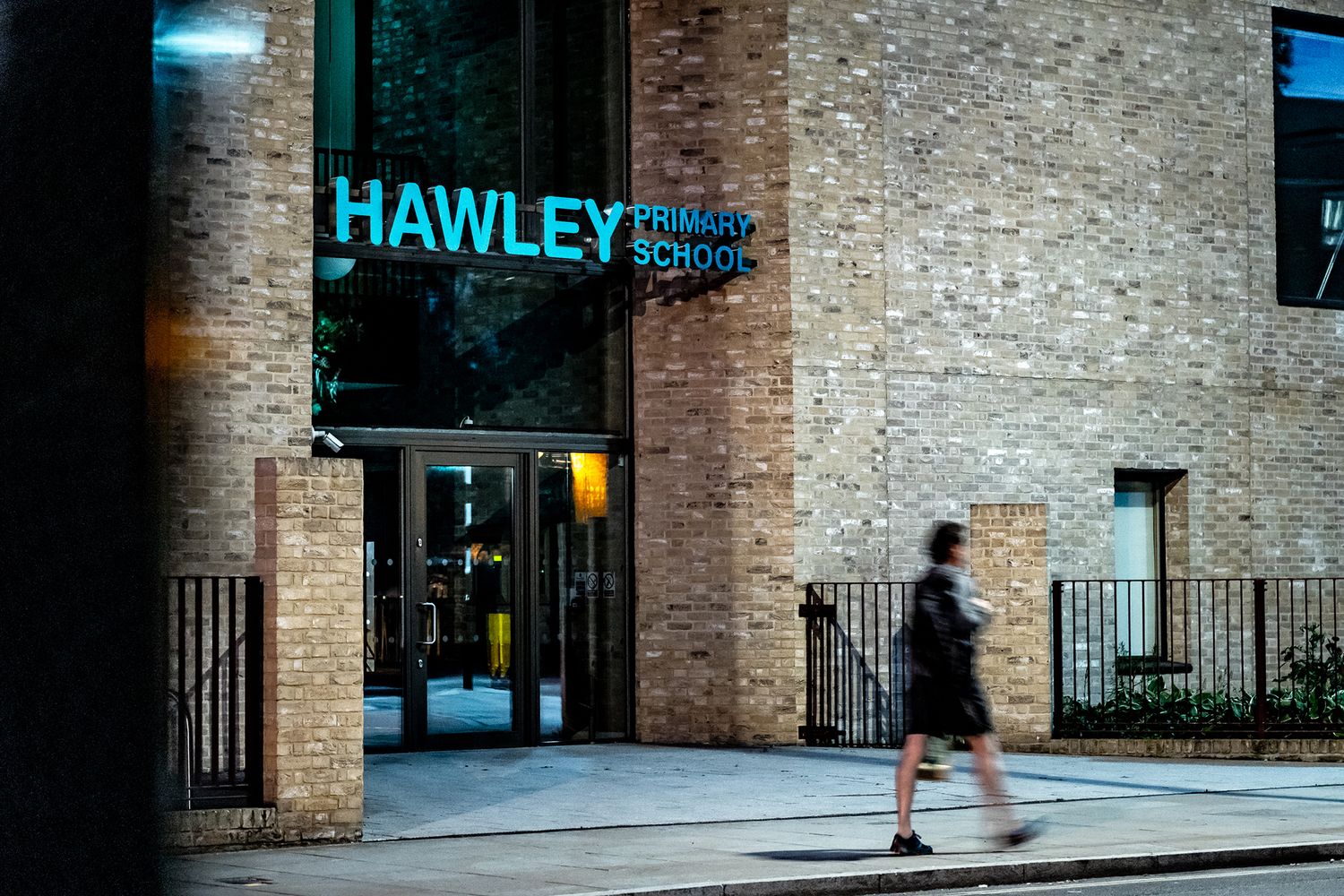 The sign at Hawley Primary School appears suspended between two walls.