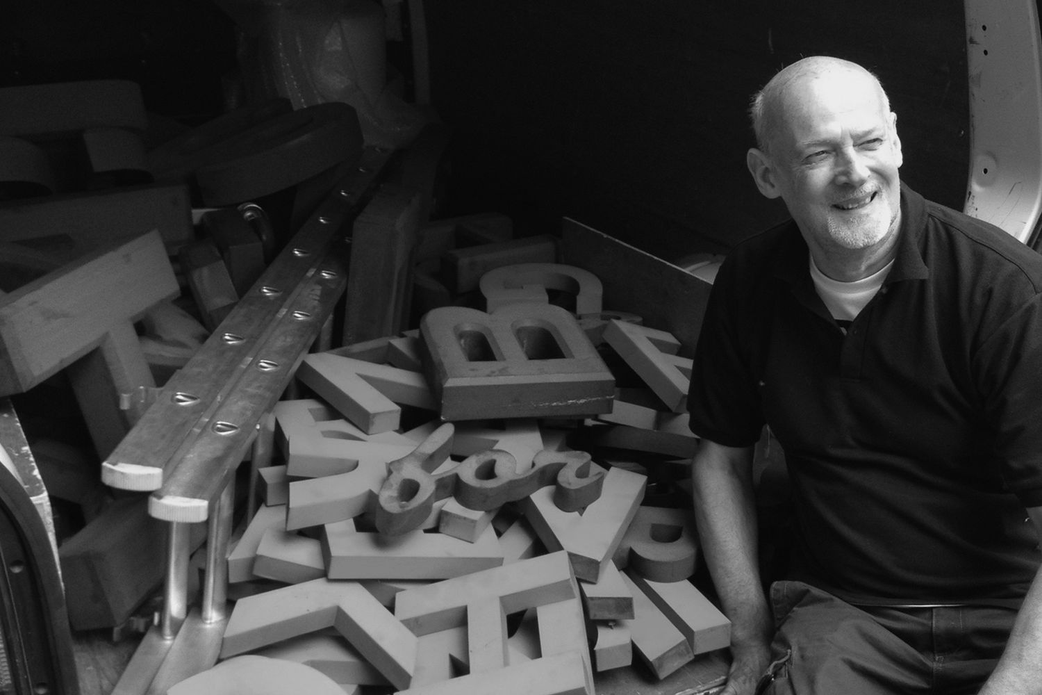 Brian in front of a van full of vintage sign letters