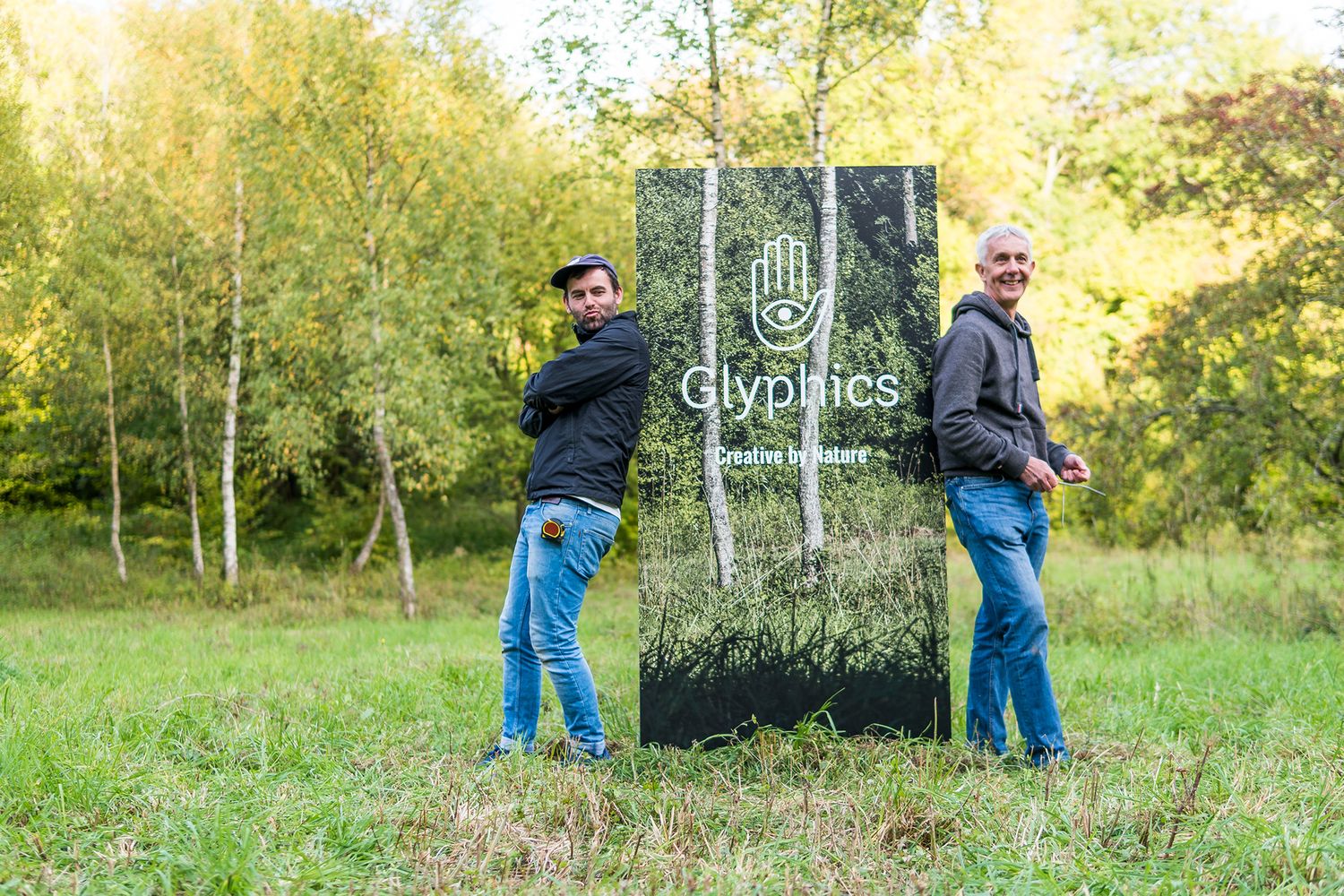 Glyphics vinyl experts pause with a vinyl covered wood panel mimicking the woods around it.