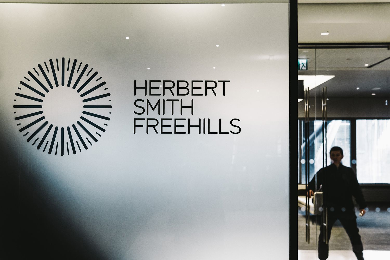 Close up of black Herbert Smith Freehills logo in frosted vinyl