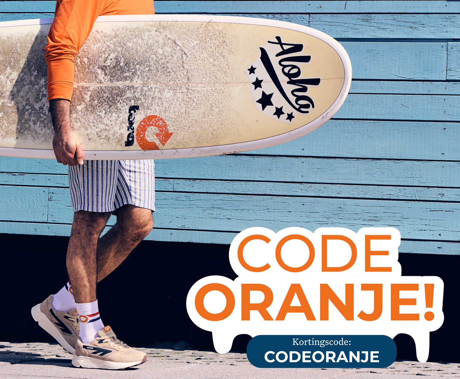 Man in orange holding surfboard, wearing shorts and sneakers, stands by a blue wall. Text: "CODE ORANJE! Kortingscode: CODEORANJE".