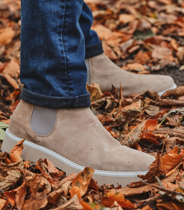 Close up van schoenen tussen de herfstbladeren