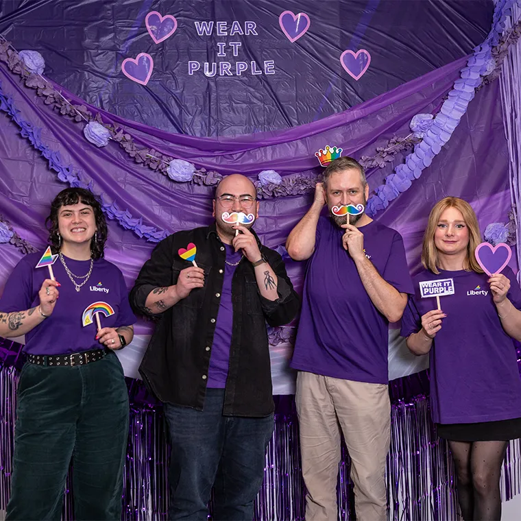 Four Liberty staff members dressed in purple
