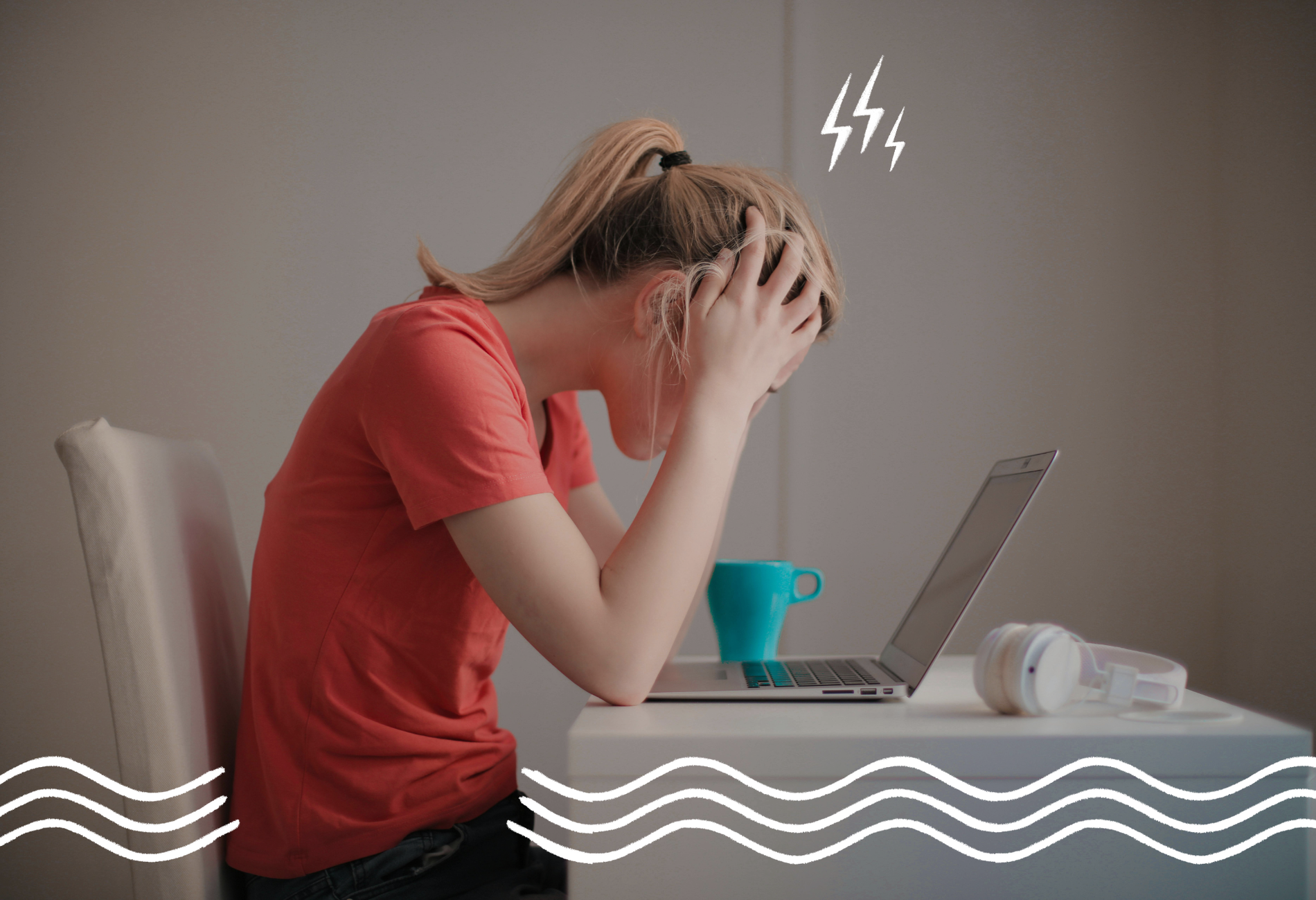 Eine blonde Frau im roten T-Shirt sitzt auf einem weißen Stuhl an einem weißen Schreibtisch vor ihm Laptop, sieht gestresst aus und vergräbt ihren Kopf in den Händen. Auf dem Tisch liegen noch Kopfhörer und eine türkise Tasse.