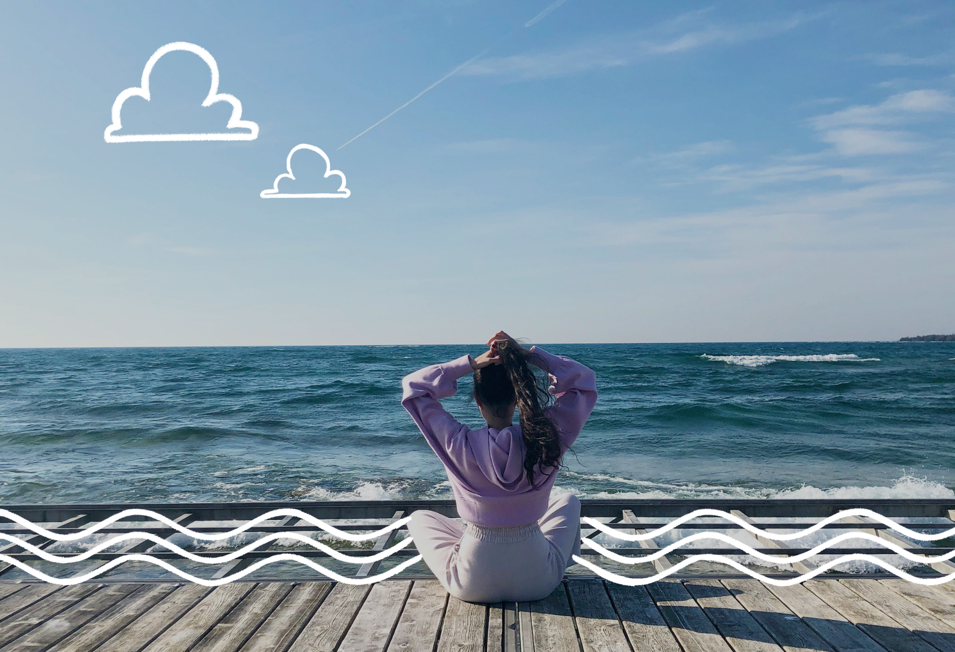 Back view of a woman sitting on the pier facing a calm ocean