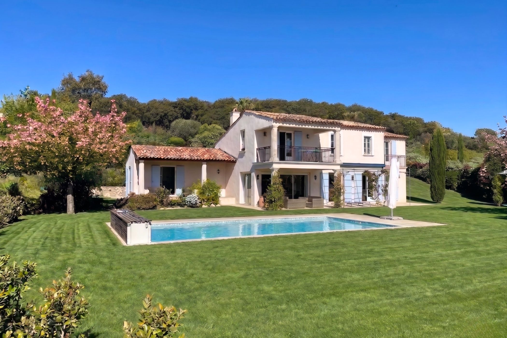 Una villa del sur de Francia cerca de Grimaud con terraza y piscina, el Massif des Maures boscoso elevándose detrás