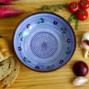 a handmade blue ceramic plate with flower paintings