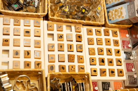 Wooden stamps with various designs, including animals and symbols, displayed in baskets on a table.
