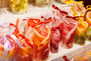 Star-shaped candles in vibrant shades of orange, yellow, and red are clustered together. The warm tones create a cozy, festive ambiance.