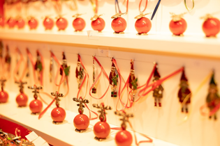 Rows of red Christmas ornaments and festive decorations displayed on shelves.