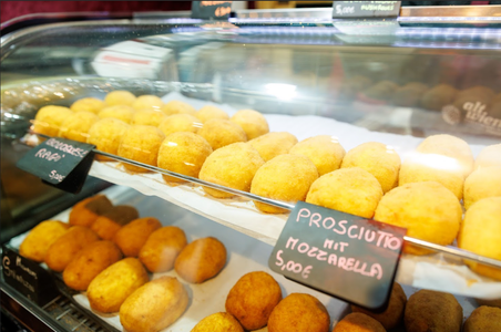 A tray filled with golden-brown arancini, each crisp and round, arranged neatly and ready to be served.