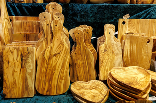 cutting boards made of olive wood displayed on a christmas market stall