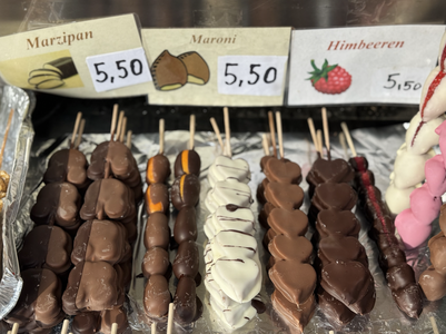 Assorted chocolate-covered treats on sticks, labeled marzipan, maroni, and himbeeren, priced at 5.50 each.