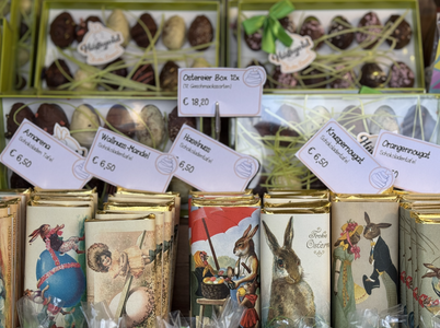 A display of Easter-themed chocolate boxes and bars featuring vintage-style bunny illustrations, with price tags in Euros.