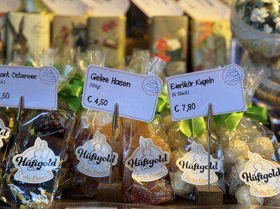 A display of packaged sweets in a store, labeled "Gelee Hasen" and "Eierlikör Kugeln," priced at €4.50 and €7.80, respectively.
