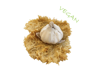 A garlic bulb sits on two crispy rounds of vegan cheese. The word "VEGAN" is written in green above.