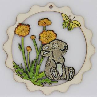 Wooden ornament with a cute rabbit sitting among yellow flowers and a butterfly, framed by a scalloped edge.