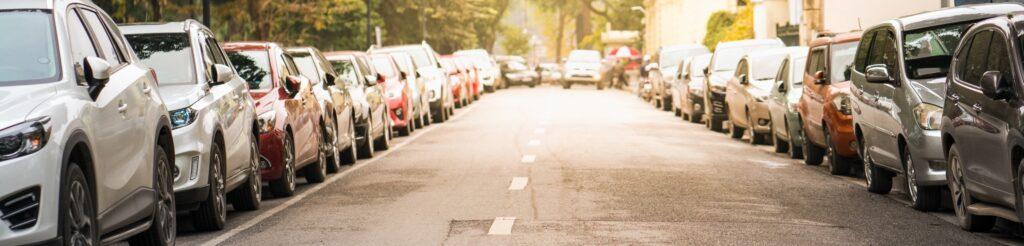 Street parking with cars parked either side of the road.