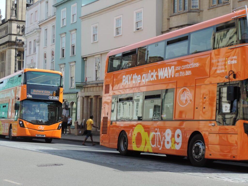 Two double-decker orange buses