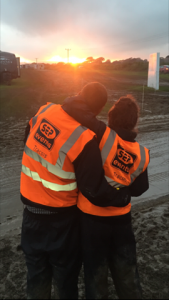 A couple of marshals posing for a photo in front of a sunset