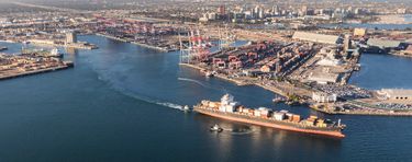 The port of Long Beach, with a large cargo ship pulling out of port.