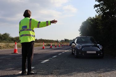 A person in a high visibility jacket directing traffic