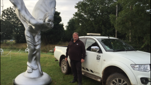An SEP team member standing next to a statue of The Spirit of Ecstasy