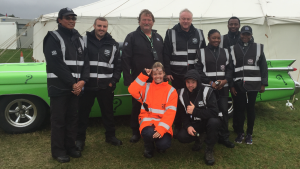 Marshals pose for a photo in front of a vintage car