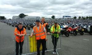 Four mashals pose for a photo in front of parked vehicles