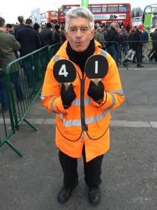 A marshal directs spectators with numbered paddles