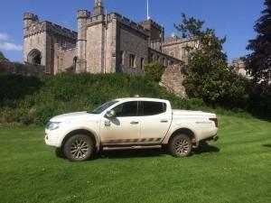 A vehicle parked in front of a castle