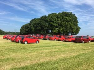 Lines of parked red vehicles in a field