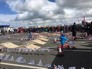Children on bikes race around a course