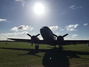 A vintage plane silhouetted by the sun