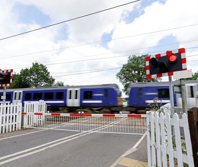 Level crossing with a train passing by.