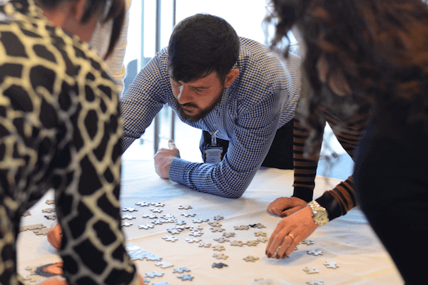 Three people working on a puzzle.