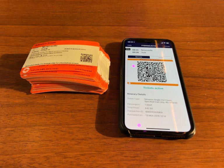 photo of a phone with a QR code and traditional rail tickets