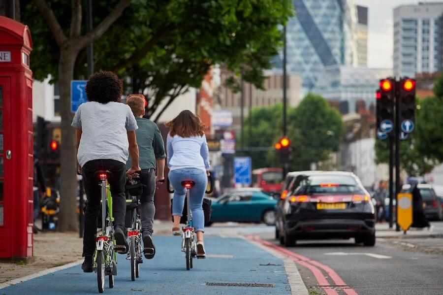 Three cyclists using the bike lane on a road.