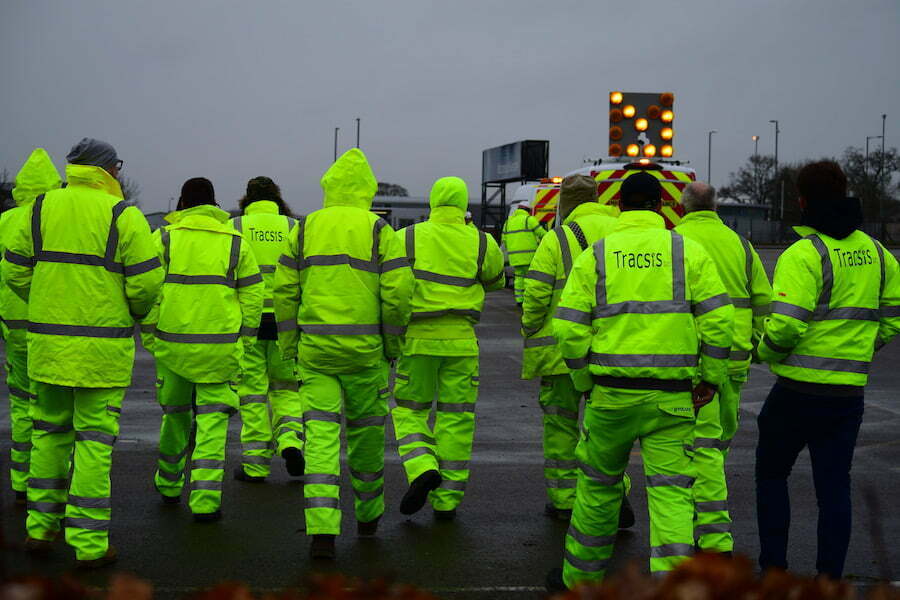 Workers in hi-vis walking away from camera.