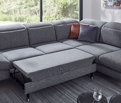 Graues Ecksofa mit Schlaffunktion für große Liegefläche.