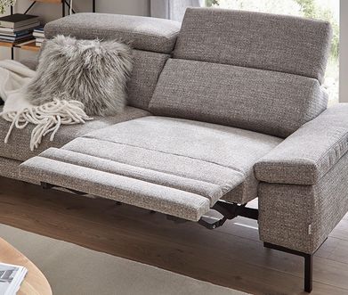 Hellgraues Sofa mit Relaxfunktion, um die Füße hochzulegen.