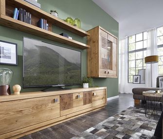 Wohnwand aus Massivholz mit Hirnholzapplikationen vor einer kräftig in Grün gestrichenen Wand