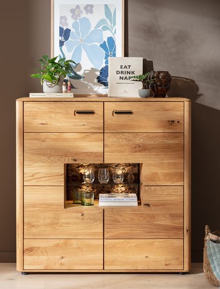 Highboard in Wildeiche im Wohnzimmer, dekoriert mit Pflanzen, Bildern und Gläsern.