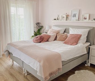 Schafzimmer in Weiß, Grau und Rosa eingerichtet.