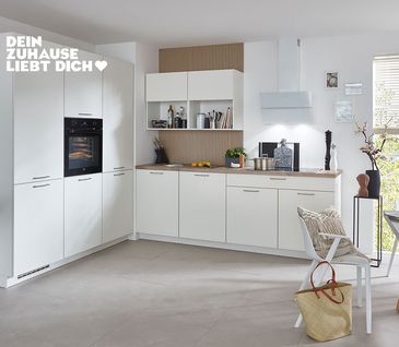 Weiße nobilia Küche in U-Form mit offenem Essbereich.