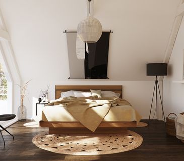 Aufgeräumtes Schlafzimmer mit Bettgestell aus Holz, dunklem Holzboden, Stuhl in Anthrazit