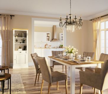 Esszimmer im Landhaus-Look mit großem Esstisch, braunen Stühlen und weißer Vitrine.