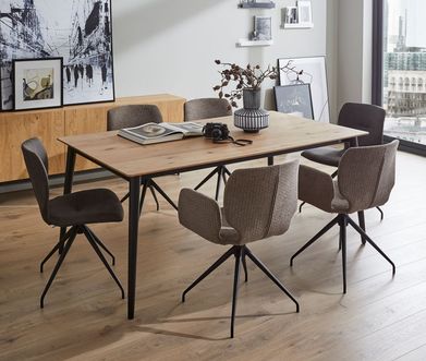 Esstisch aus Holz mit einem schwarzen Gestell um den graue Schalenstühle mit schwarzem Metallgestell stehen.