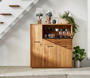 Highboard aus Massivholz mit aufgeklapptem Fach, in dem Gläser und Schalen stehen